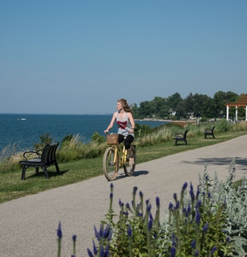 A woman riding a bike with lake erie in the background